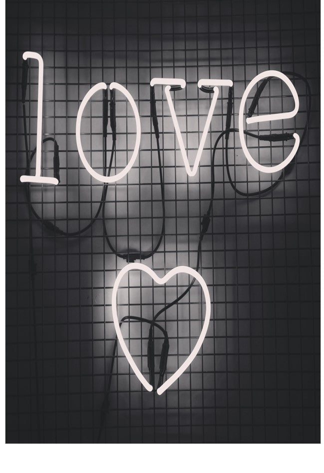 Neon sign with the word 'LOVE' and a heart shape on a dark grid background