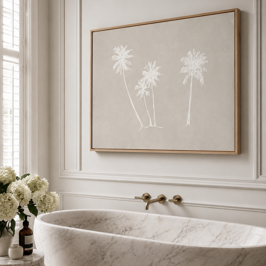 A large framed botanical canvas art print featuring three white palm tree silhouettes on a warm beige background, hanging on a white paneled wall above a luxury marble freestanding tub in a bright bathroom.