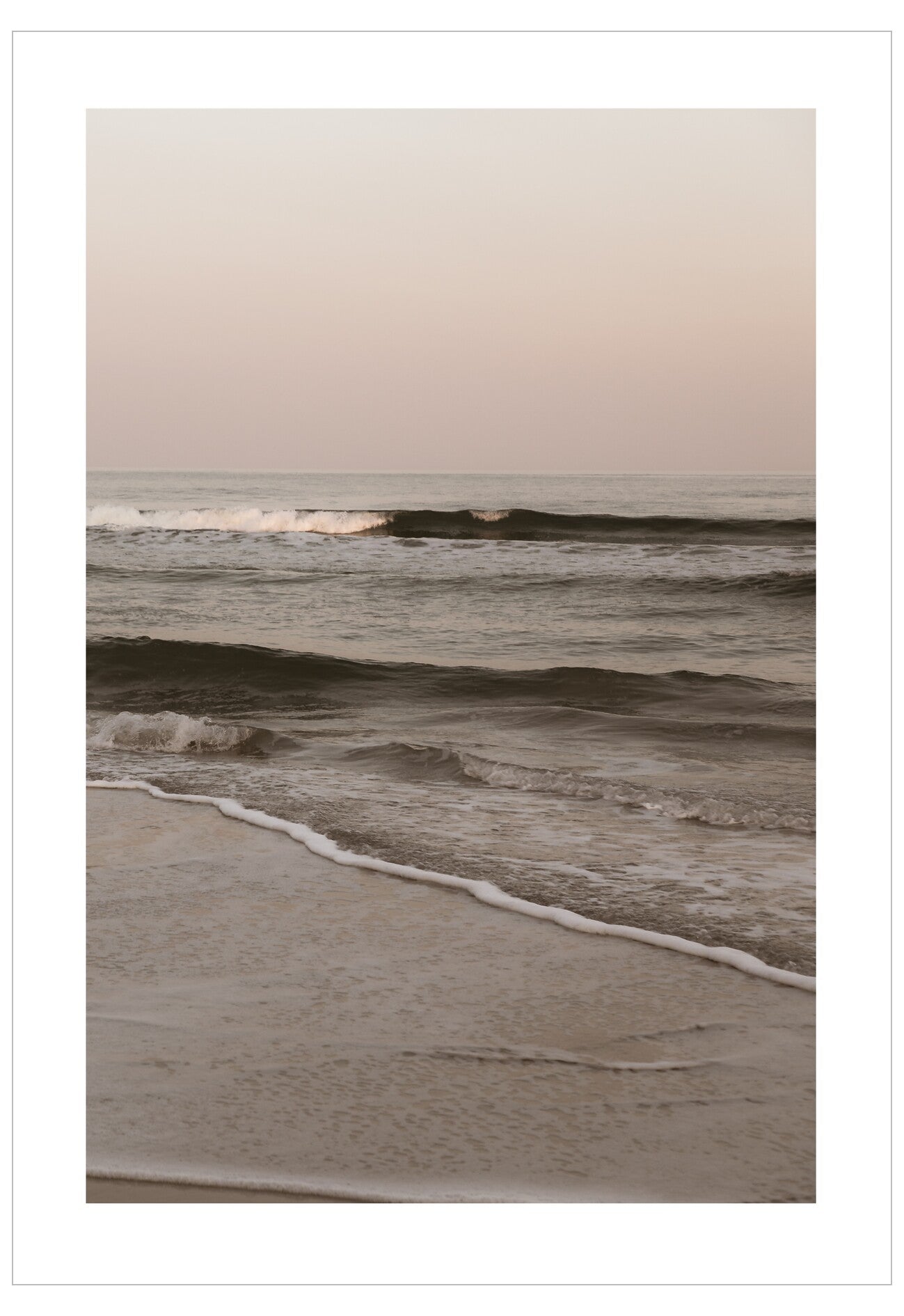 Waves crashing onto a beach with a pastel sky
