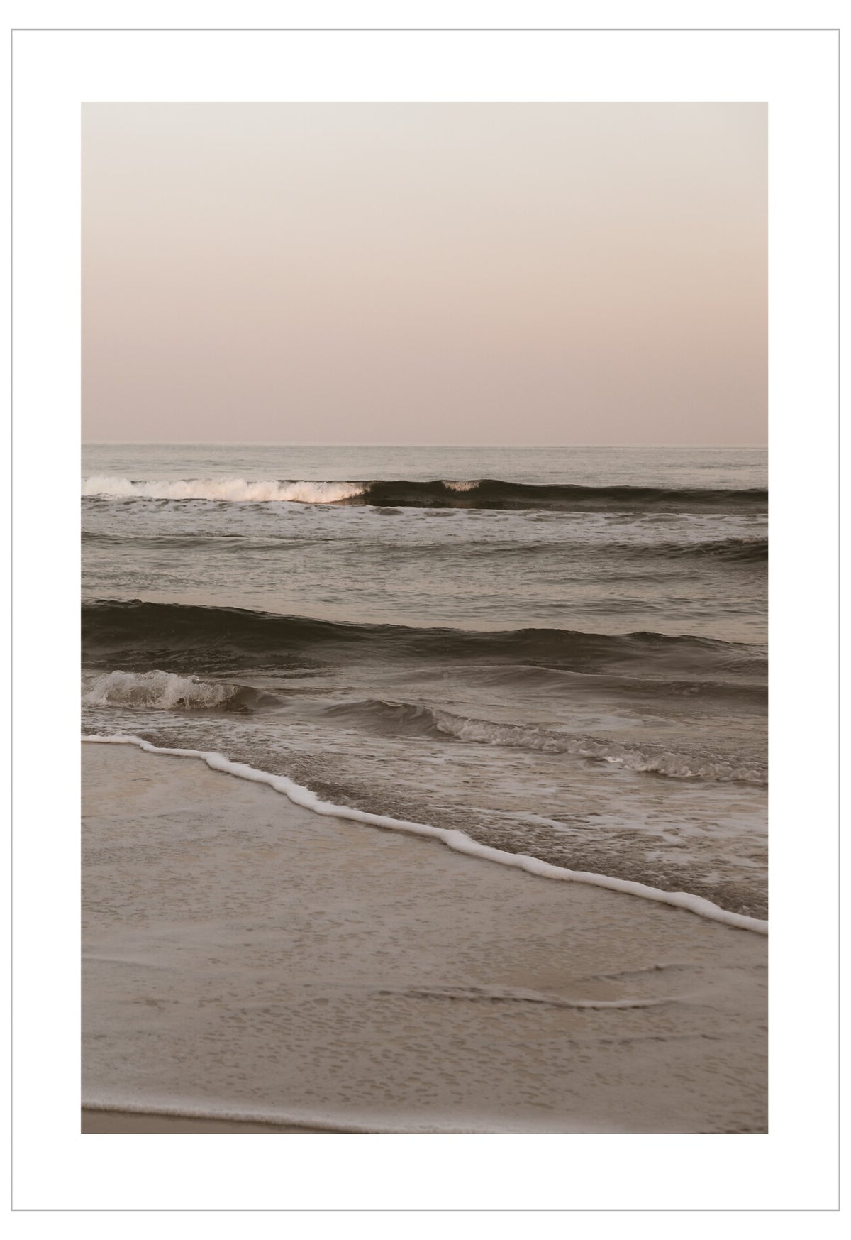 Waves crashing onto a beach with a pastel sky