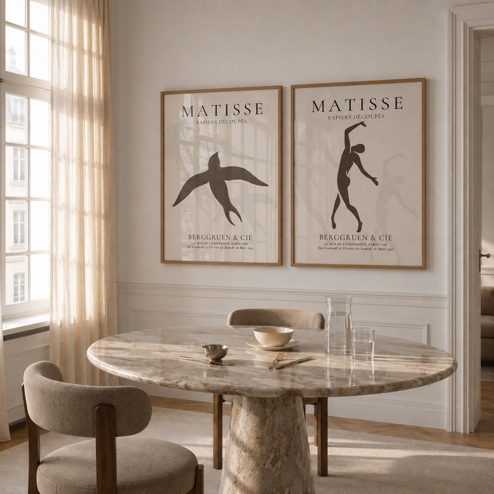 Dining room with marble table and chairs, featuring Matisse art prints on the wall.