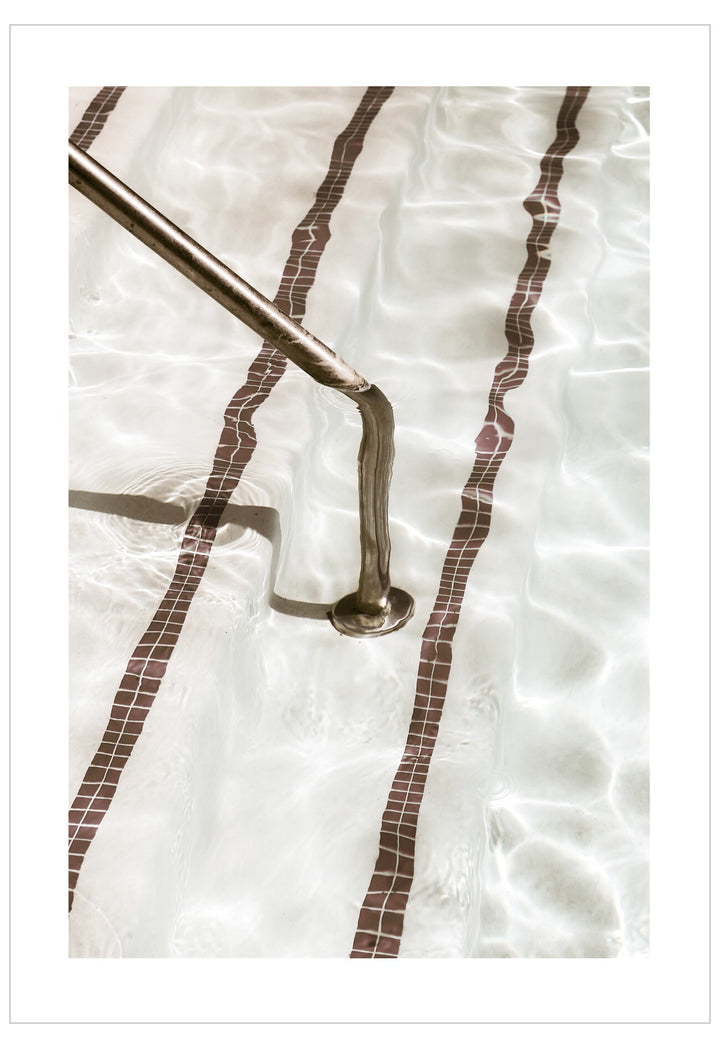Metal grab bar mounted on a tiled wall with a white background