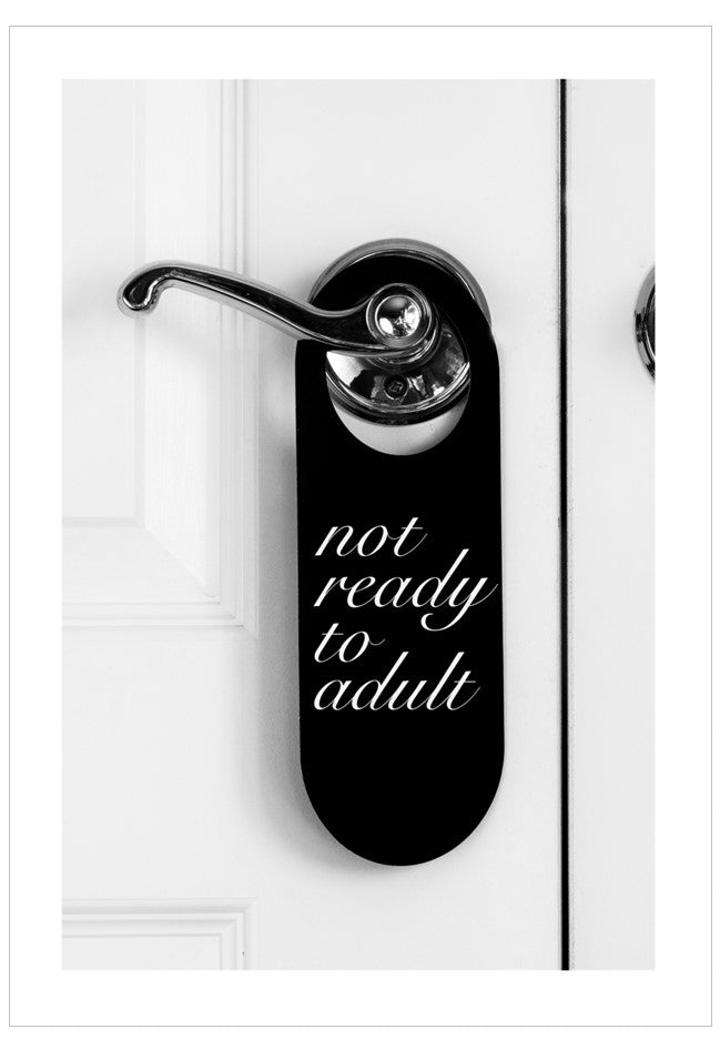Door handle with 'not ready to adult' text on a white door