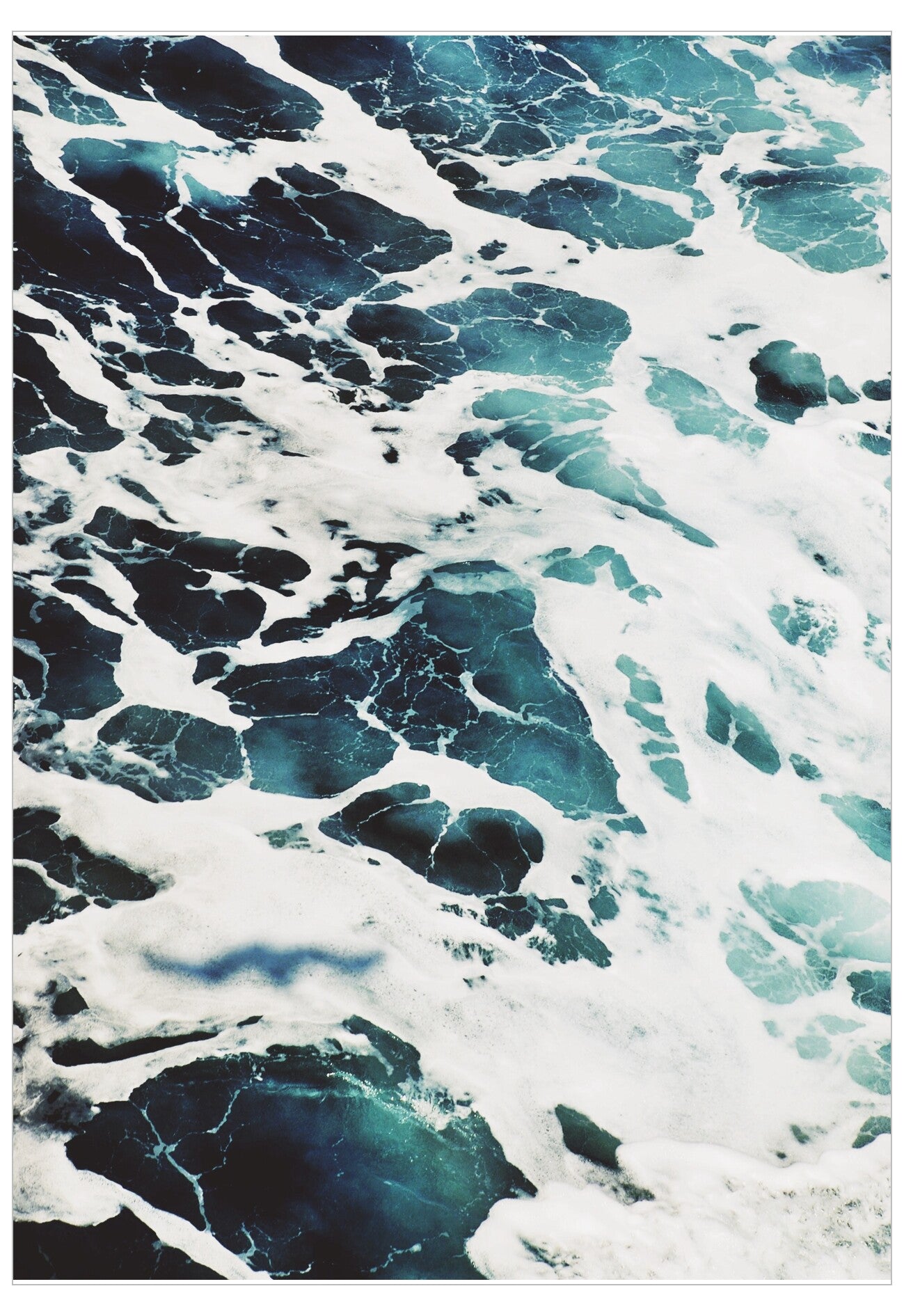 Close-up of turbulent ocean water with swirling patterns of blue and white.