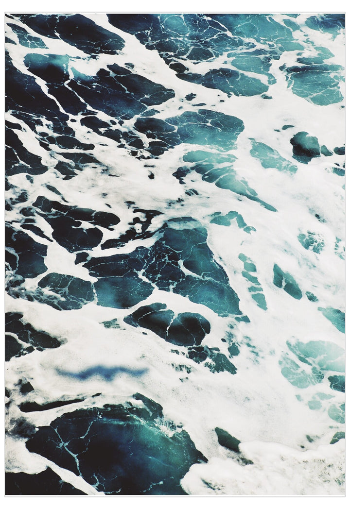 Close-up of turbulent ocean water with swirling patterns of blue and white.