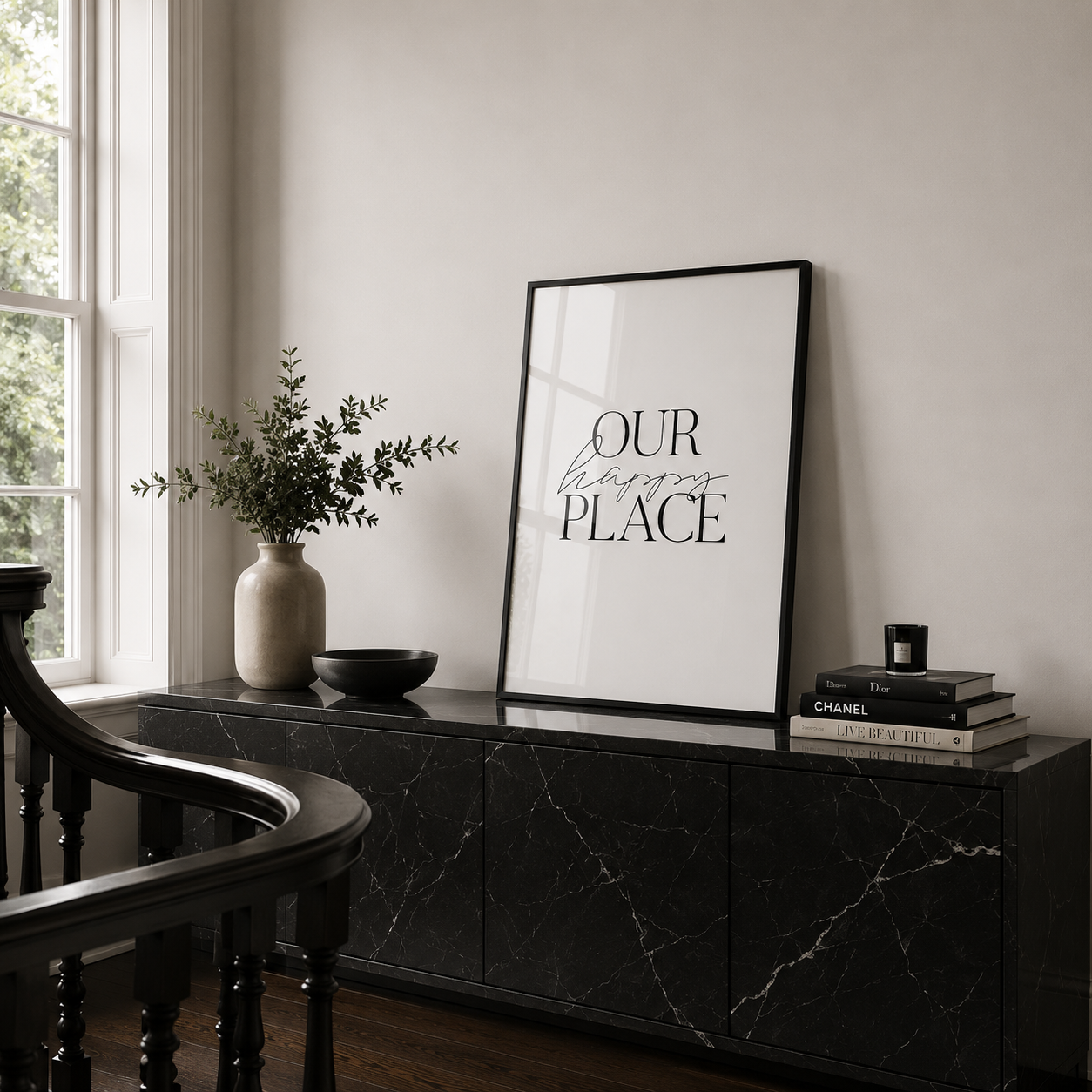 Framed artwork with 'Our Happy Place' text on a black marble console table.