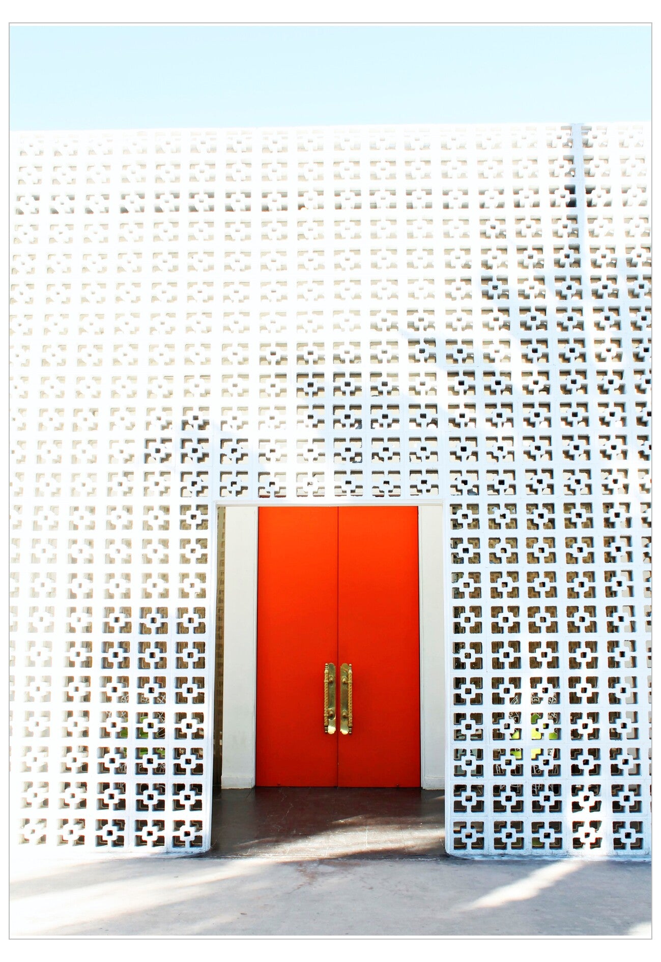 Modern architectural design with a red door and decorative white screen