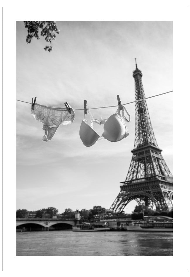 Black and white image of lingerie hanging on a line with the Eiffel Tower in the background.