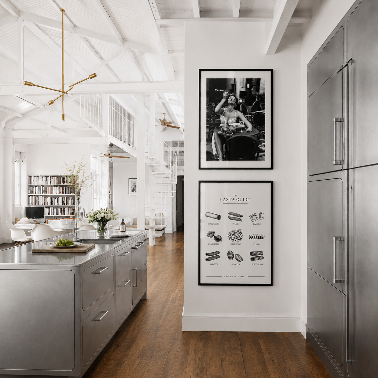 Modern kitchen with stainless steel appliances, wooden floor, and framed artwork on the wall.