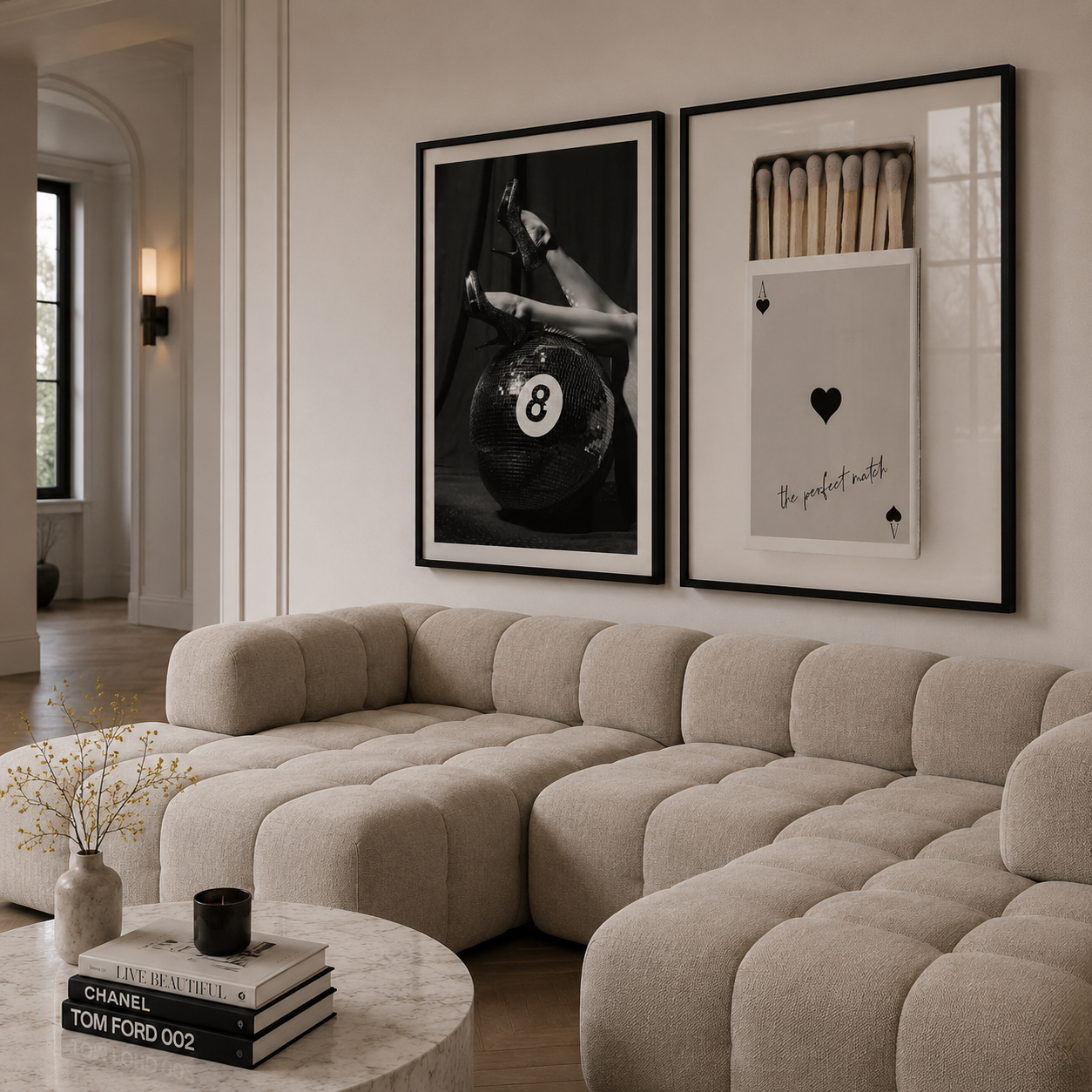 Modern living room with a beige sectional sofa, framed art on the wall, and a small round table.