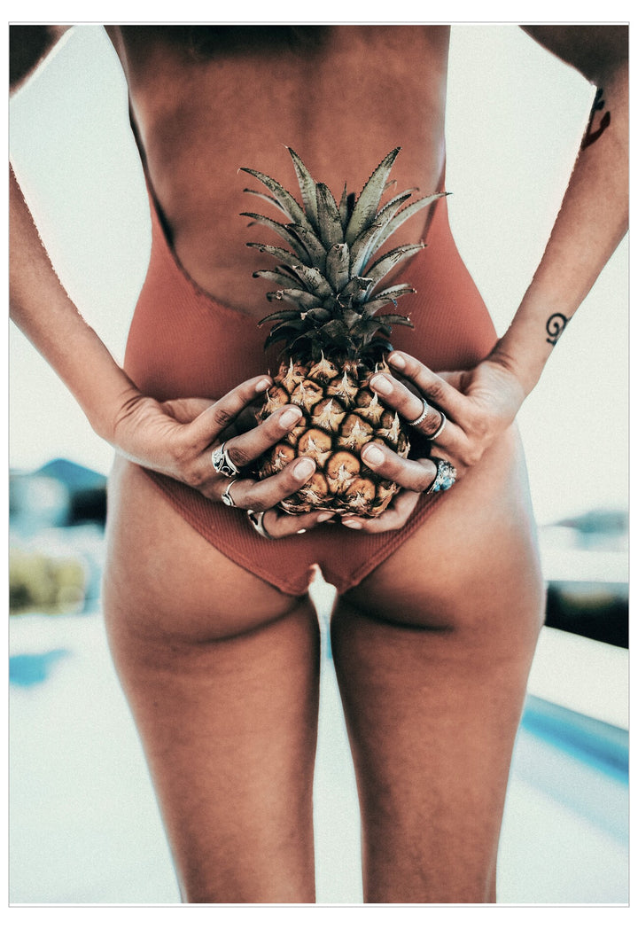 Person holding a pineapple with a blurred outdoor background