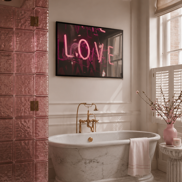 Bathroom with pink tiled walls, freestanding bathtub, and 'LOVE' neon sign.