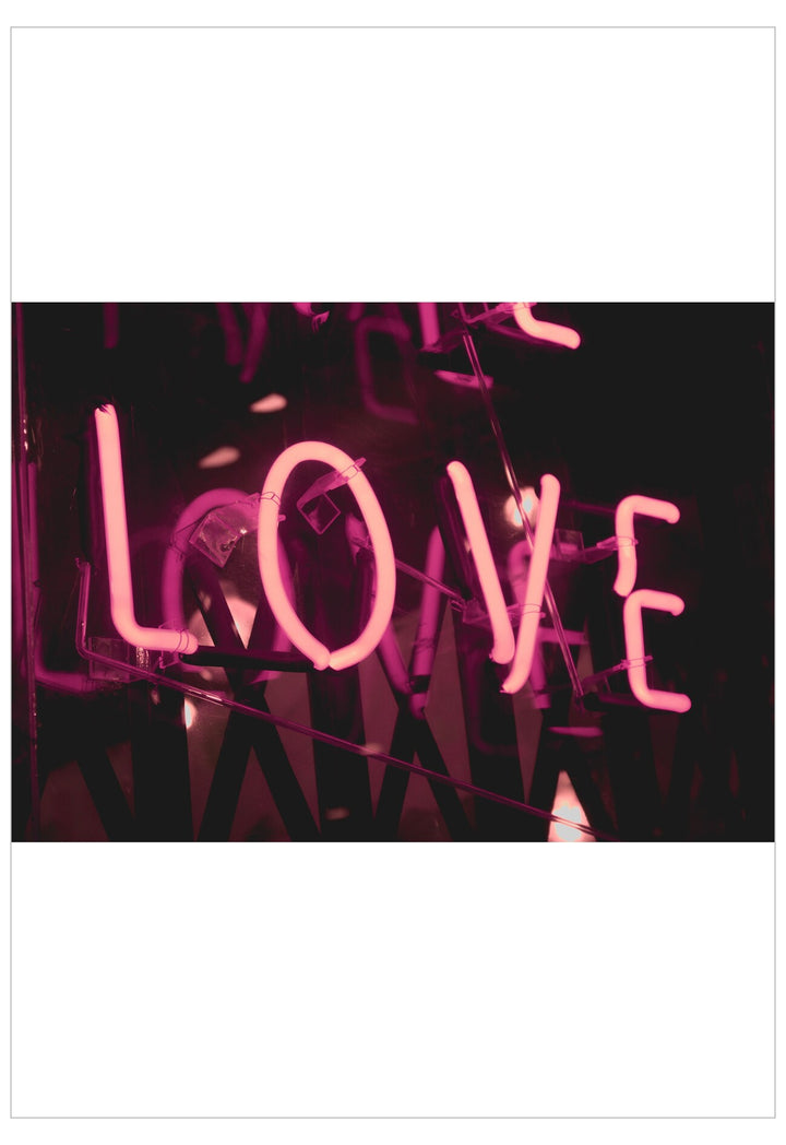 Neon sign spelling 'LOVE' in pink on a black background