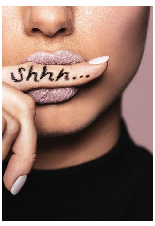 Close-up of a person's lips with a finger over the mouth, showing the word 'Shhh...'.