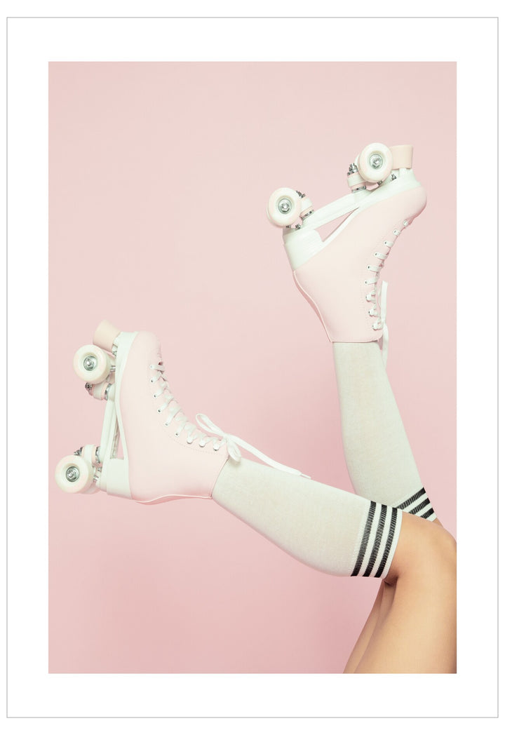 White roller skates with black stripes on a pink background