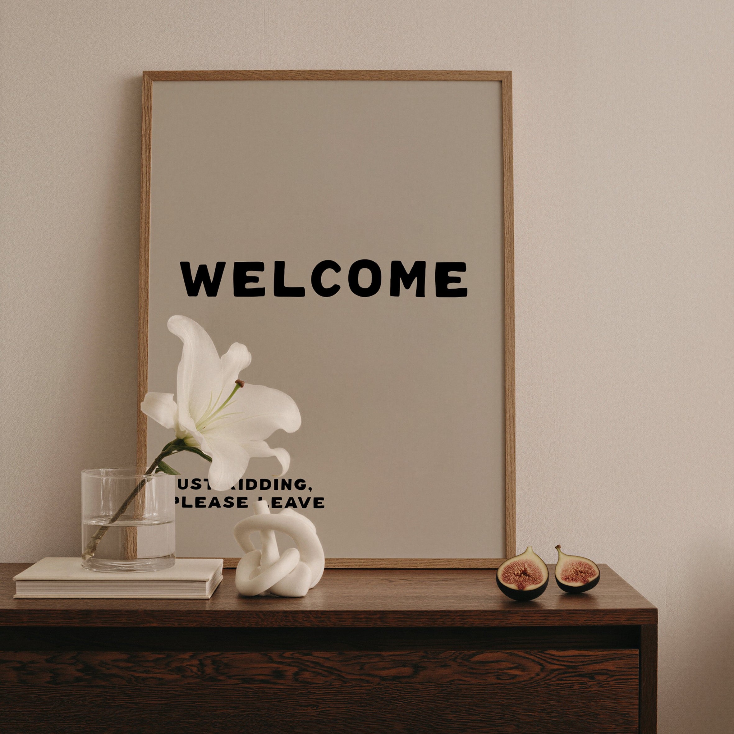 Framed 'WELCOME' sign on a wooden console table with decorative items.