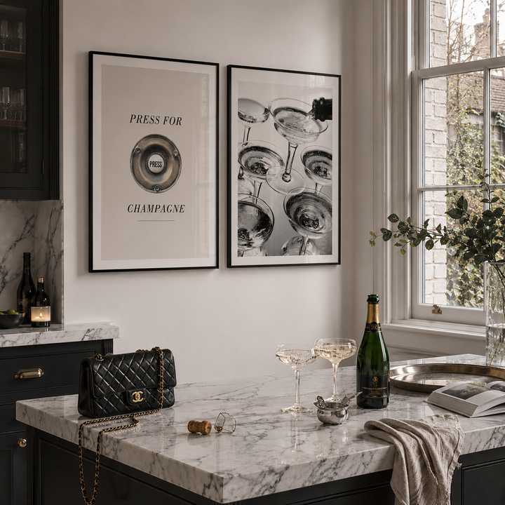 Modern kitchen with marble countertop, wine bottles, and framed art on the wall.