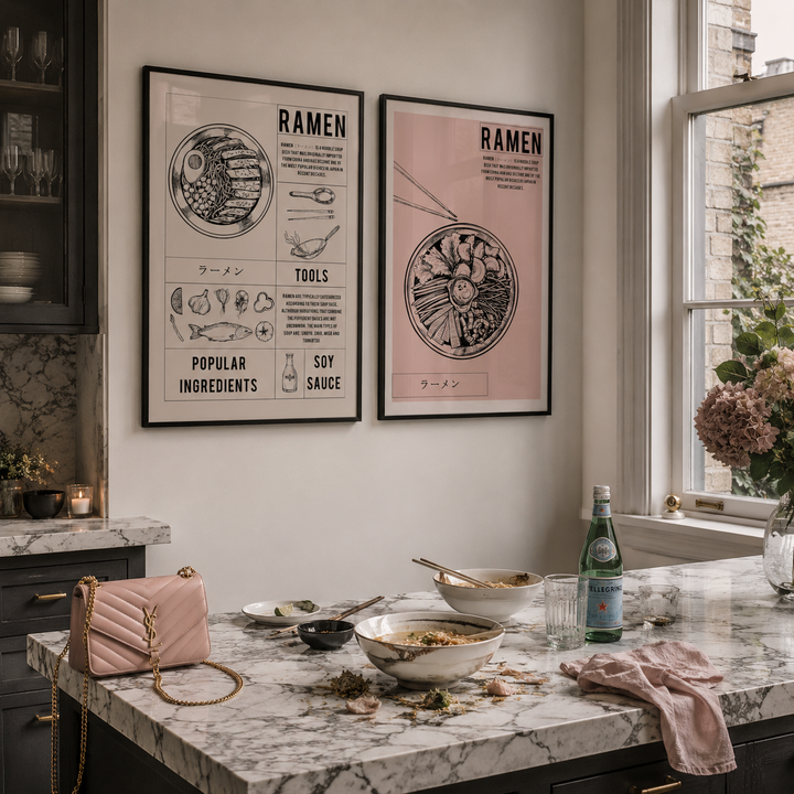 Kitchen counter with bowls, a bottle, and a pink YSL handbag, featuring 'Ramen' themed posters on the wall.