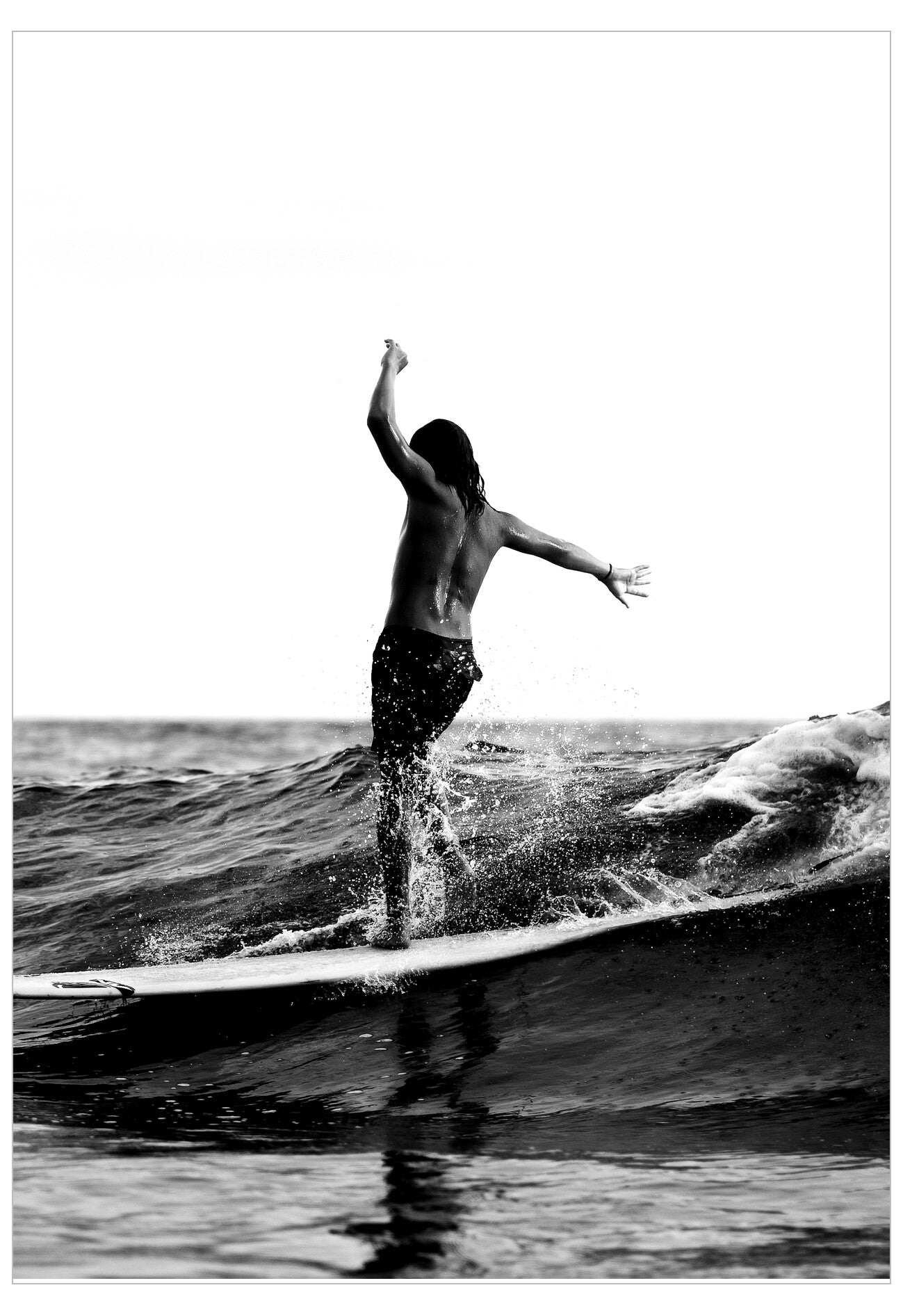 Black and white photo of a person jumping off a wave on a surfboard.