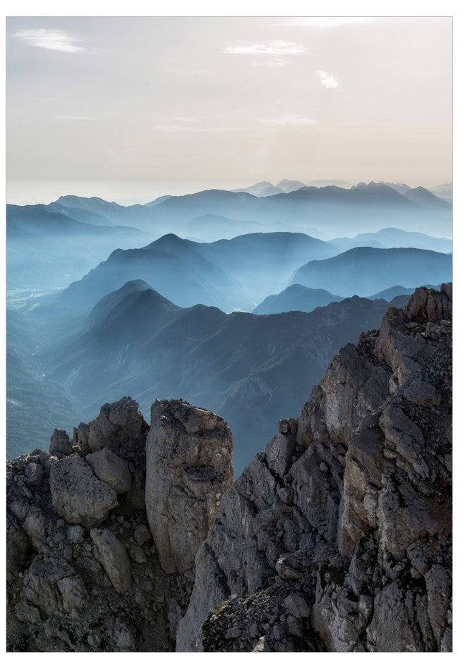 Mountain landscape with rocky foreground and misty mountains in the background