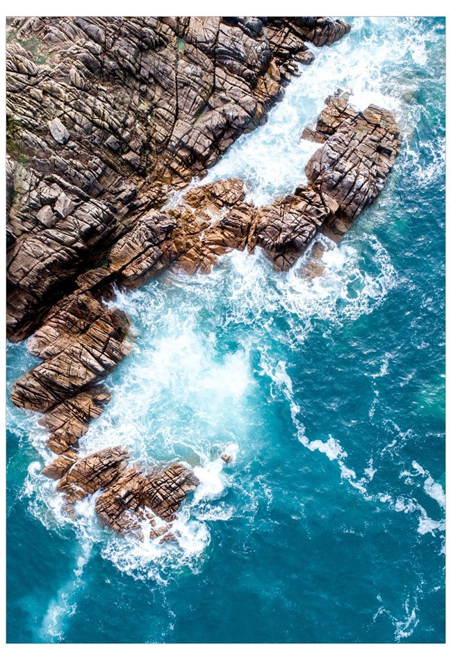 Aerial view of rocky coastline with crashing waves