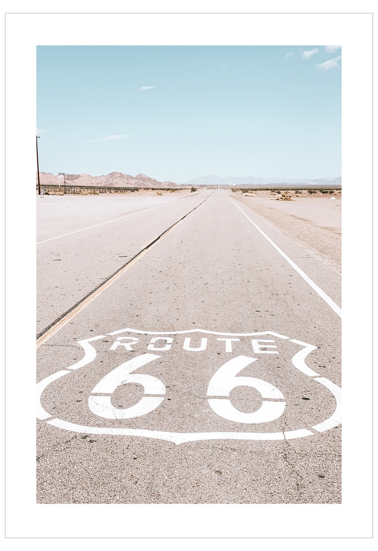 Route 66 sign on a desert road with clear sky