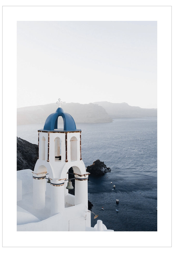White church with blue dome on a cliff overlooking the ocean