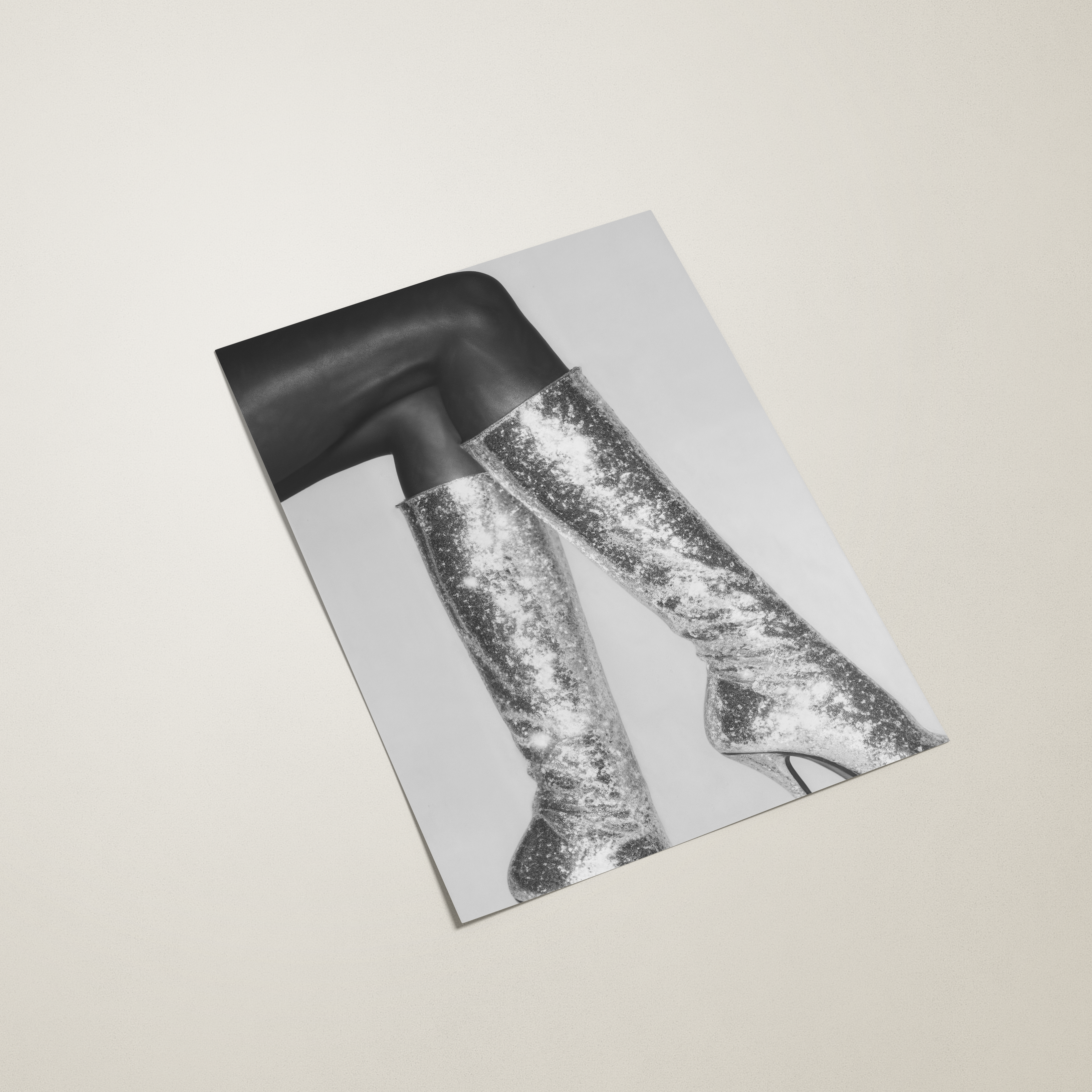 Black and white image of a person wearing high-heeled shoes on a light gray background