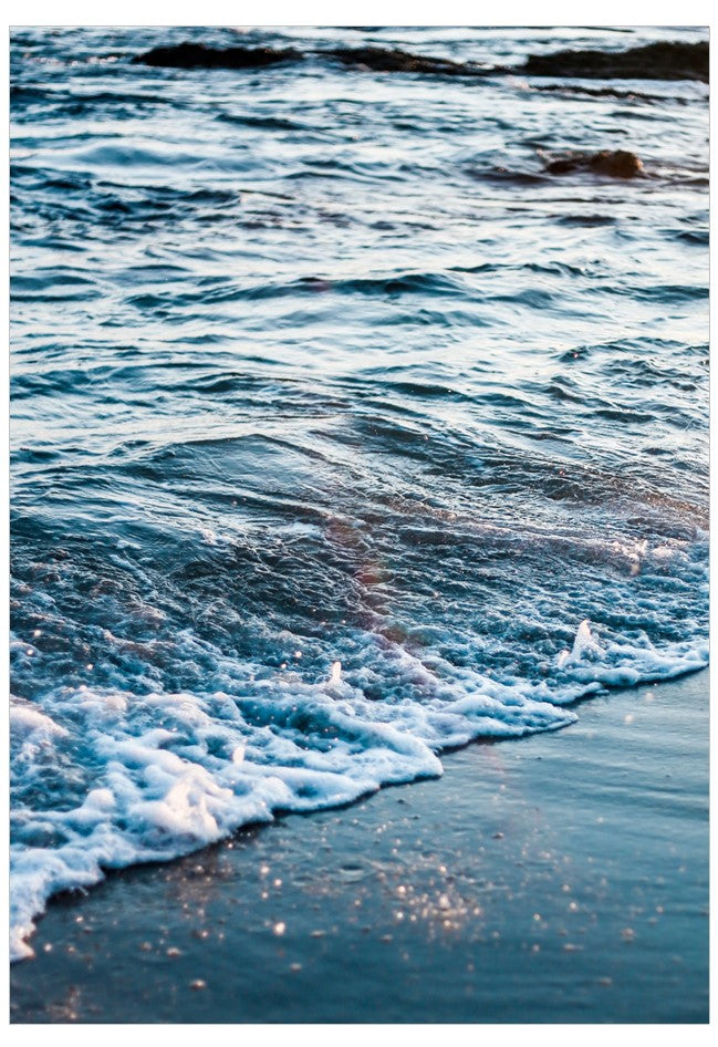 Close-up of ocean waves crashing onto a sandy beach