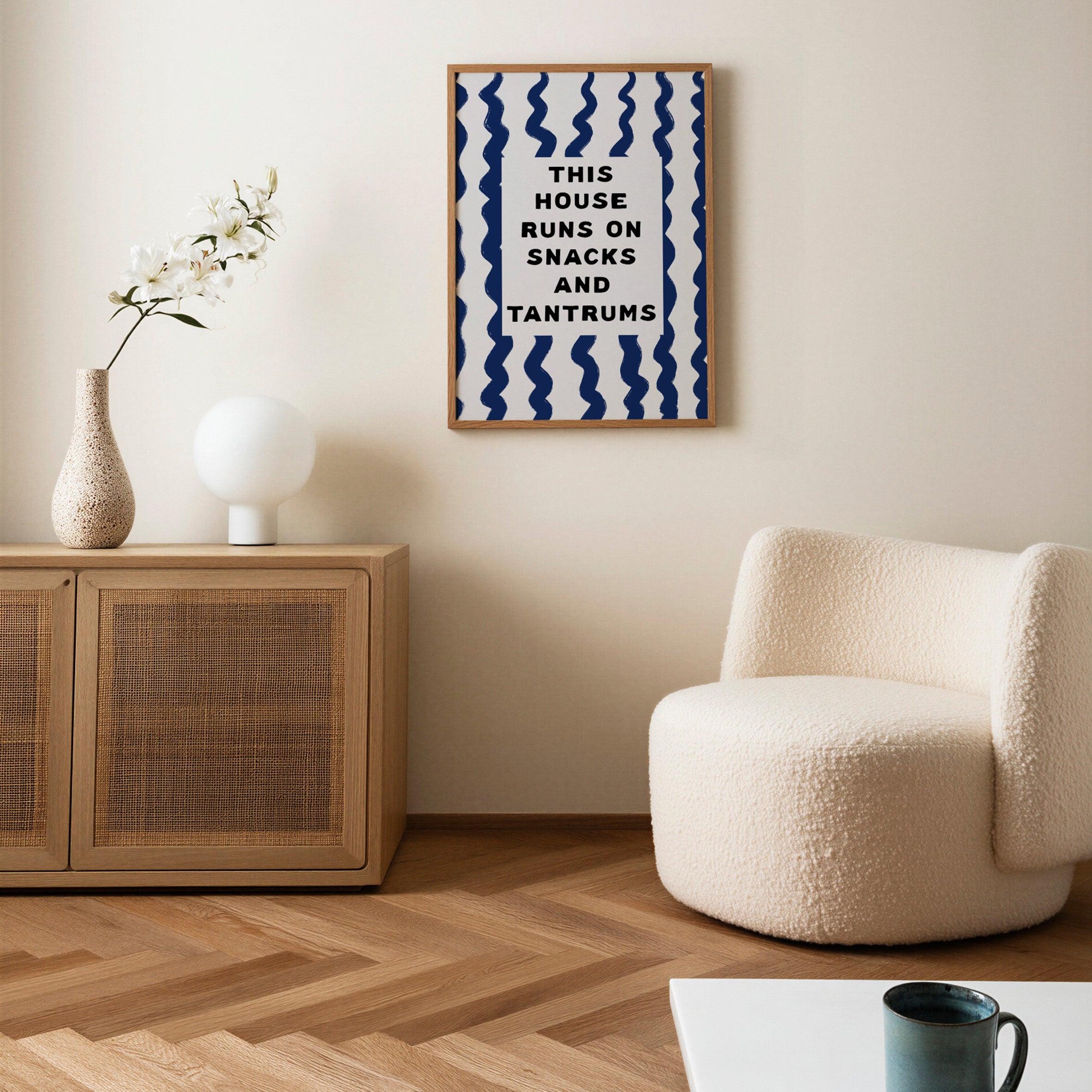 Modern living room with a textured armchair, wooden cabinet, and framed quote on the wall.