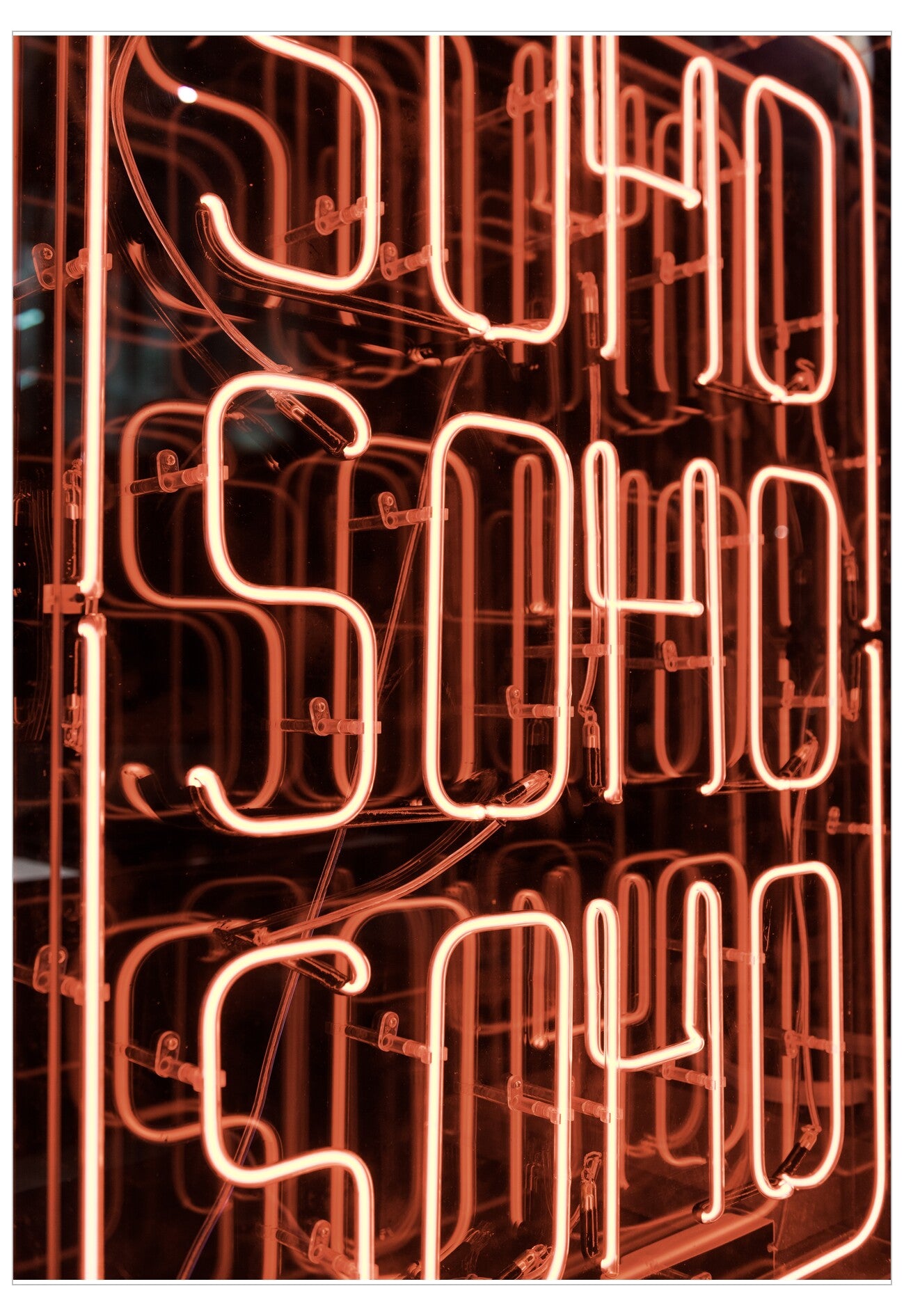 Neon sign with 'SOHO' text on a dark background