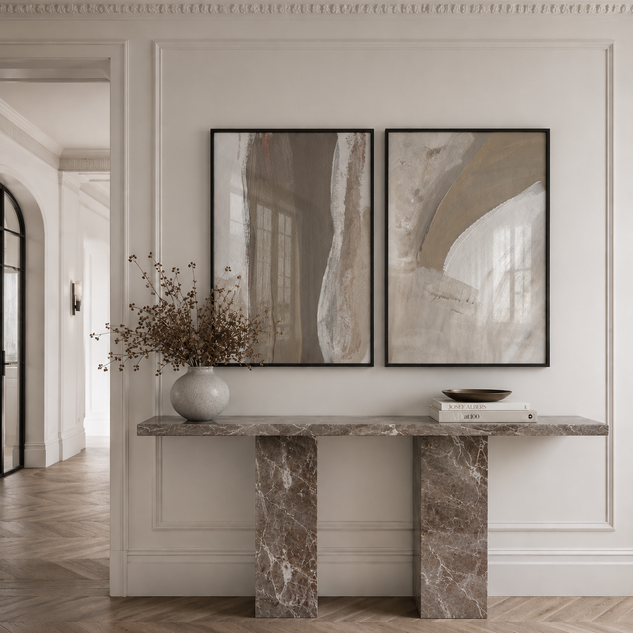 Marble console table with decorative items against a wall with abstract art