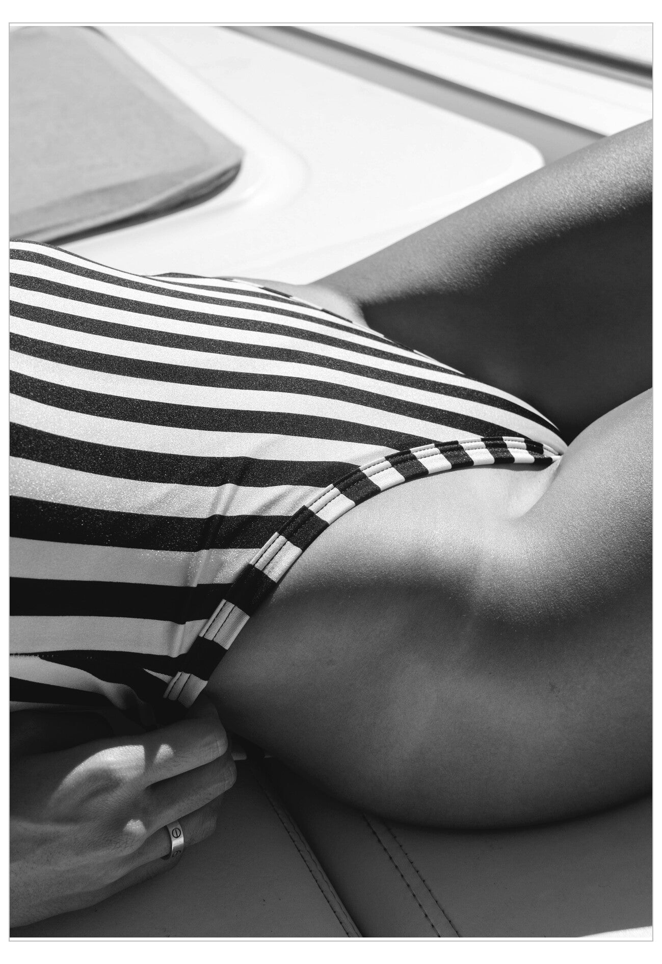 Person wearing a black and white striped swimsuit in a car.
