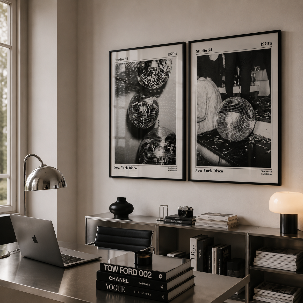 Modern office space with framed black and white artworks on the wall, books, and a laptop.