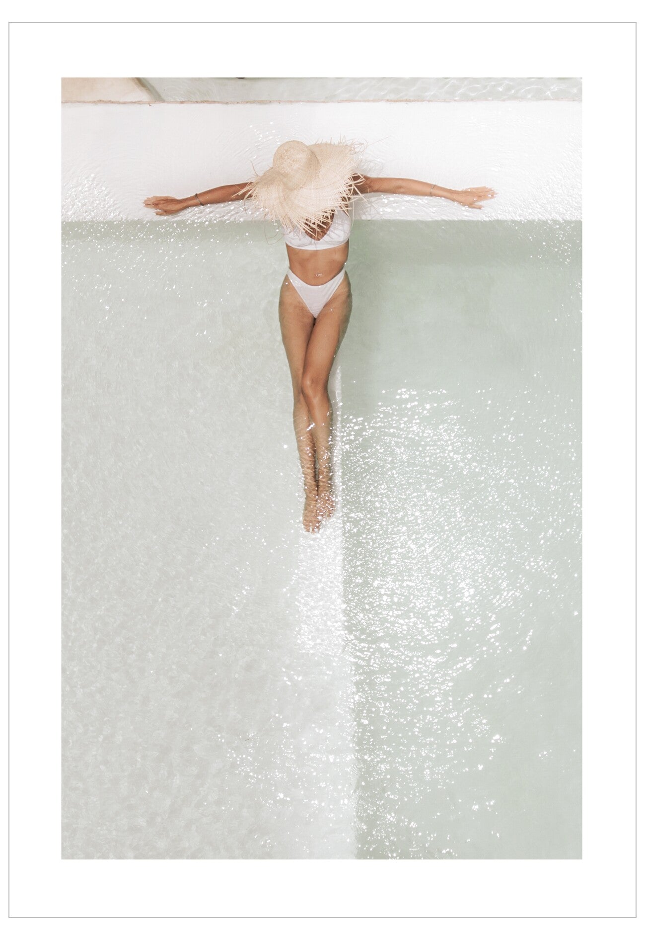 Person in a white swimsuit floating in a pool with a glittery bottom