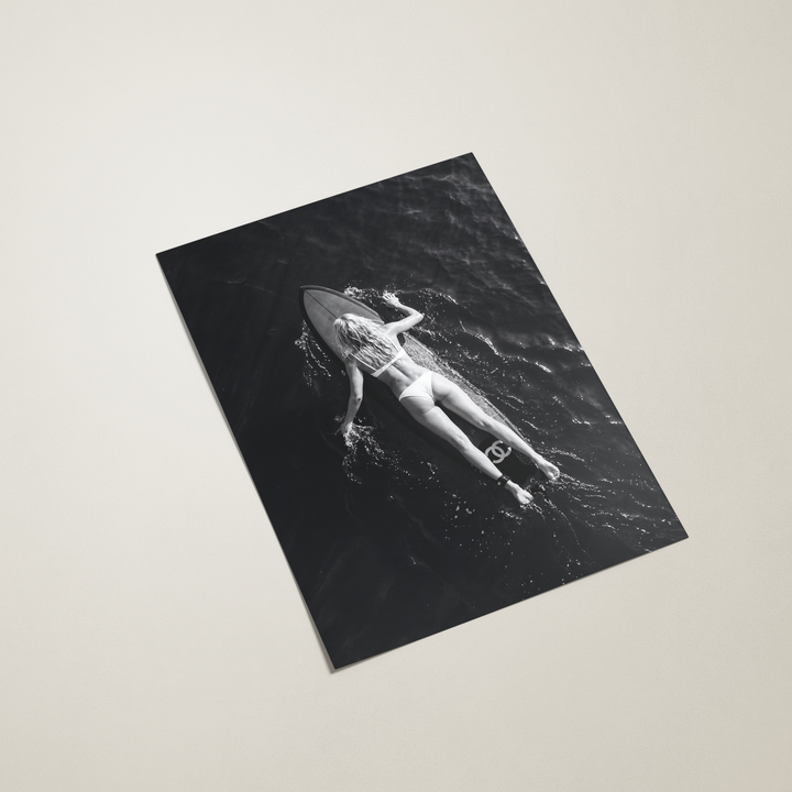 black and white poster of woman surfing on beige background