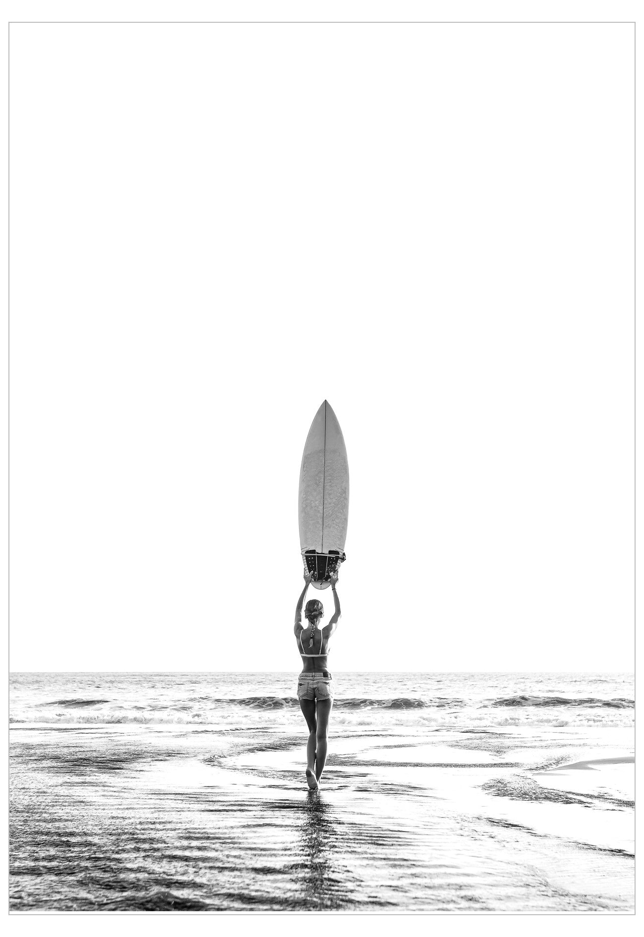 Person holding a surfboard above their head on a beach