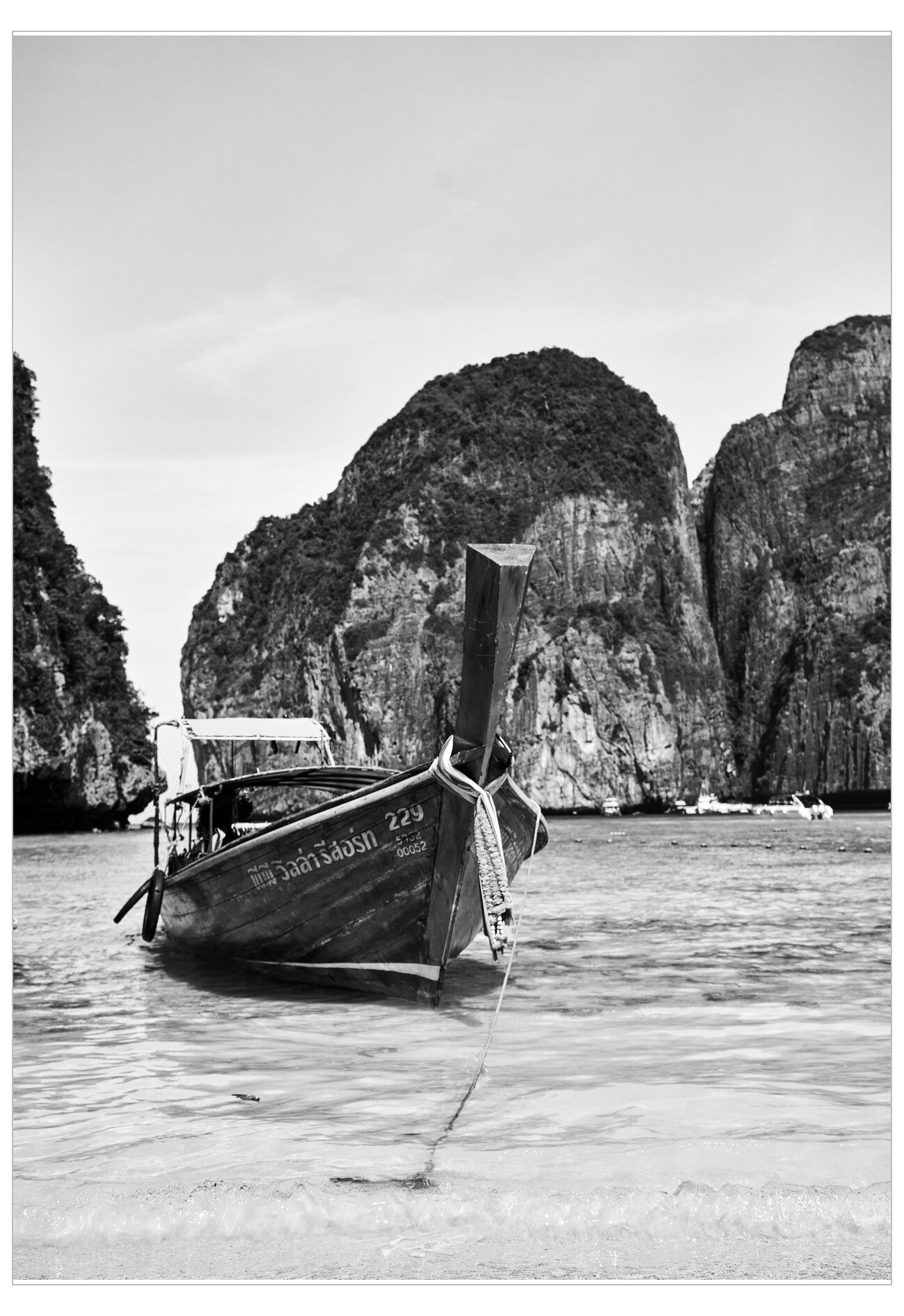 Traditional wooden boat on water with rocky cliffs in the background