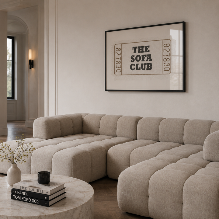 Beige sectional sofa in a living room with a framed poster on the wall.