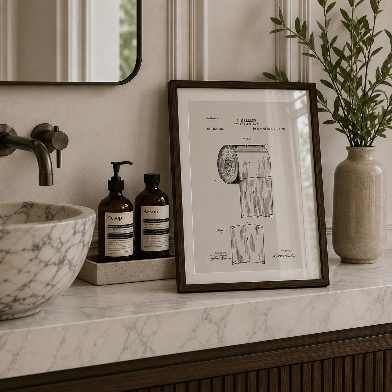 Bathroom counter with framed patent print, bottles, and a vase.