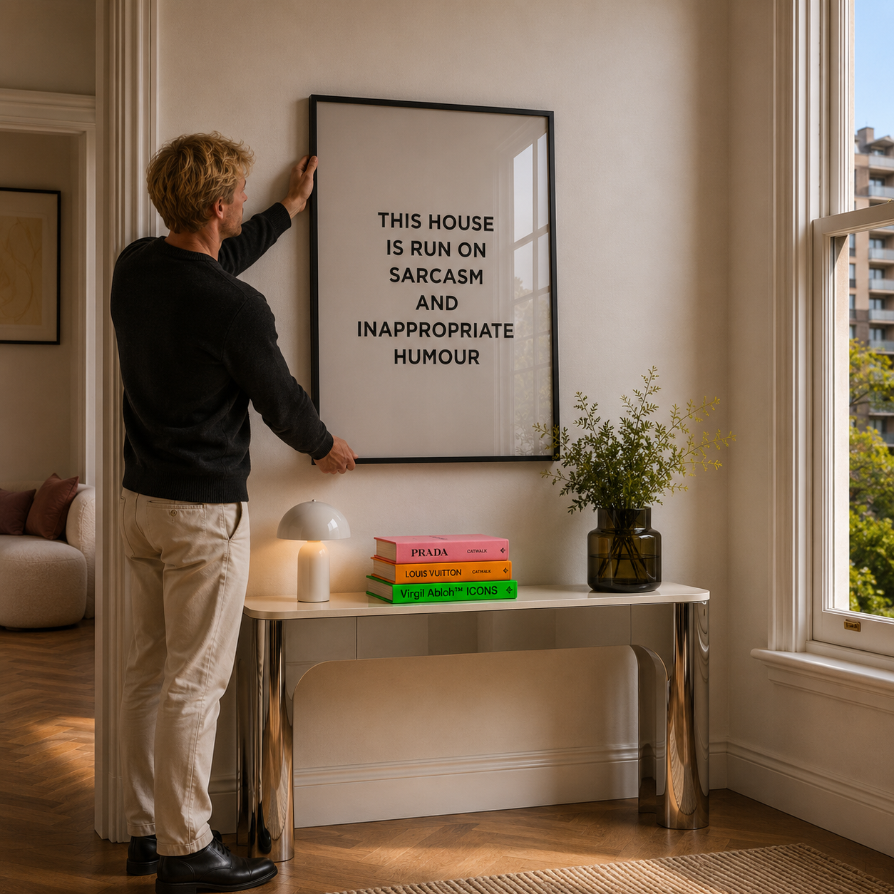 Person adjusting a framed quote on a wall in a room with a table and decor items.