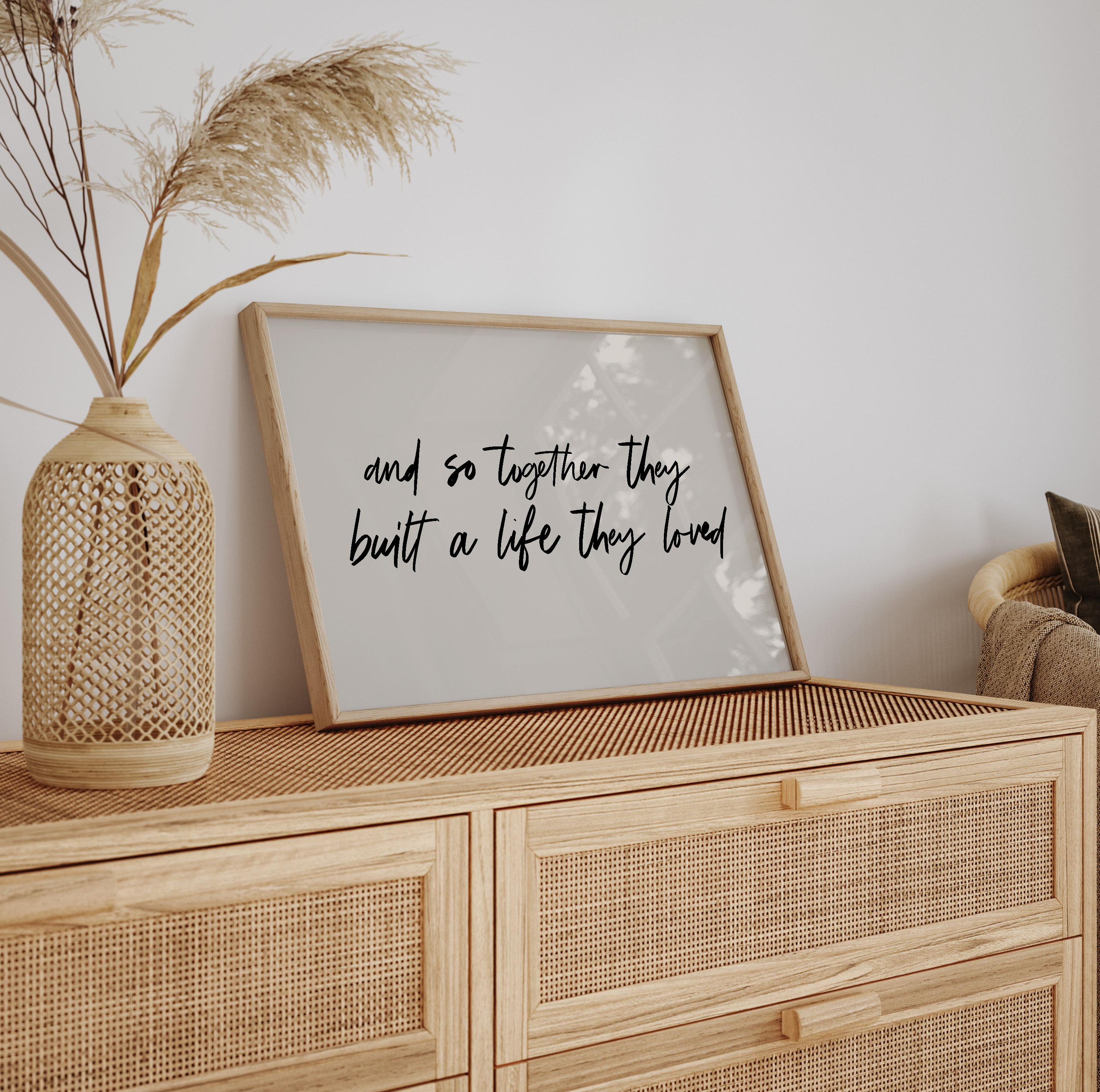 Wooden cabinet with a framed quote and decorative vase on a light background