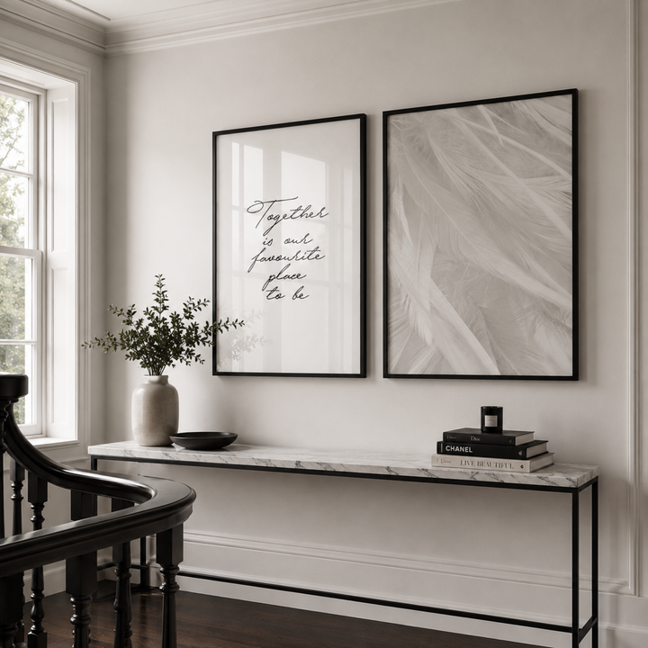 Decorative wall art with text and abstract design in a room with a console table and chair.