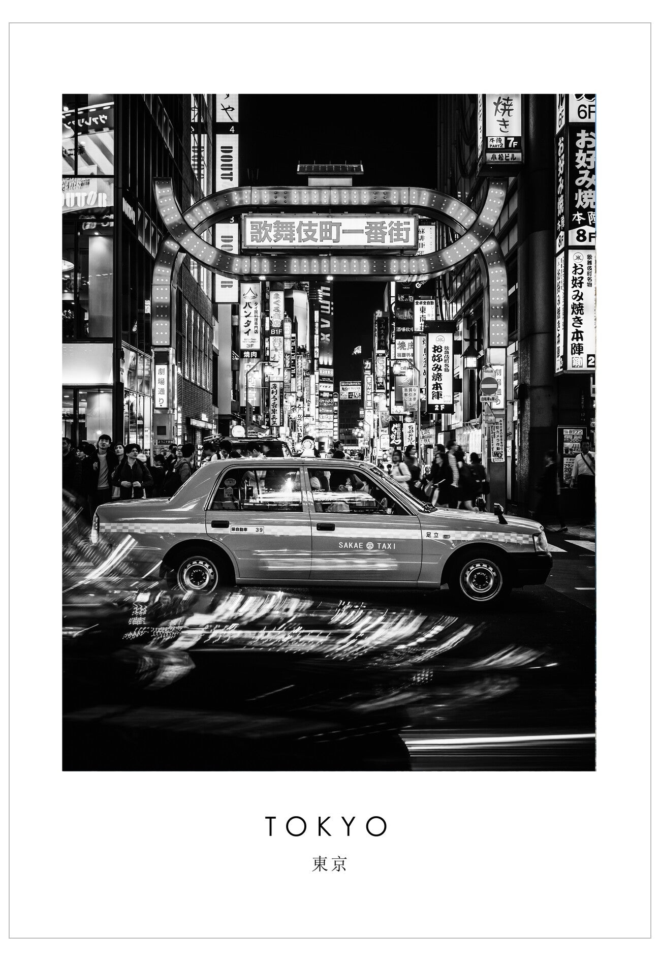 Black and white image of a taxi in a bustling Tokyo street at night.