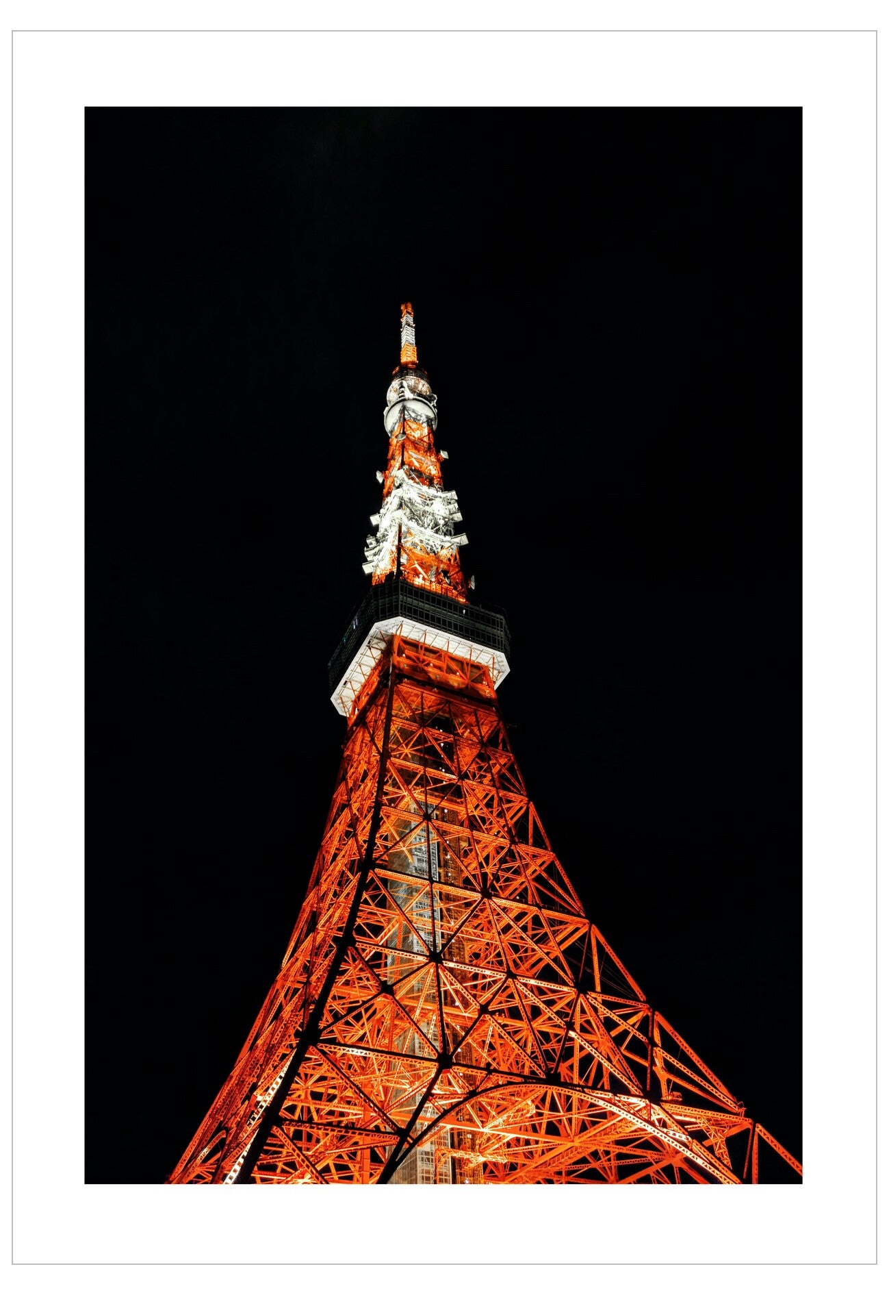 Tokyo Tower illuminated at night against a black sky