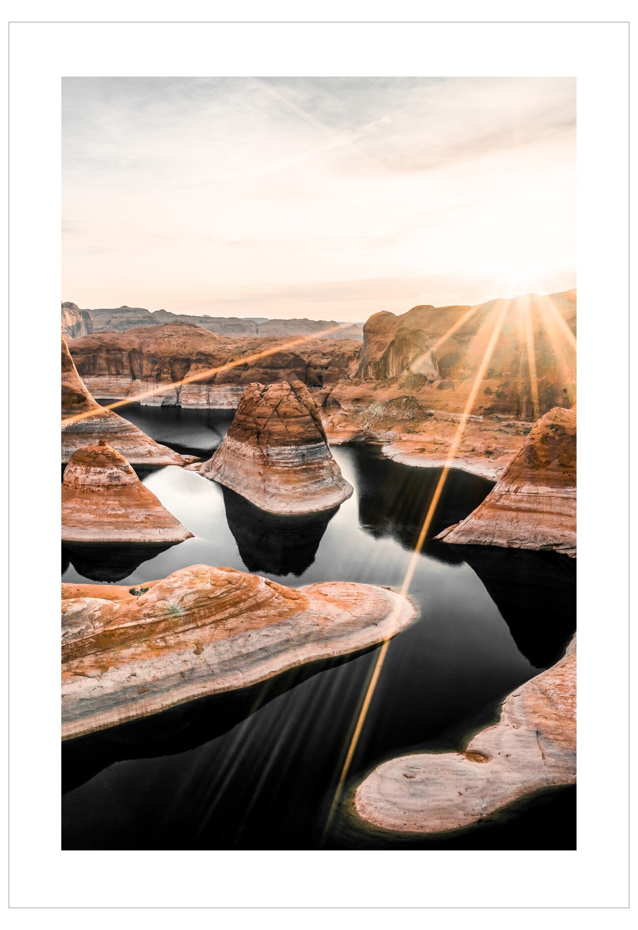 Reflective water surface with sandstone formations and a sunburst effect