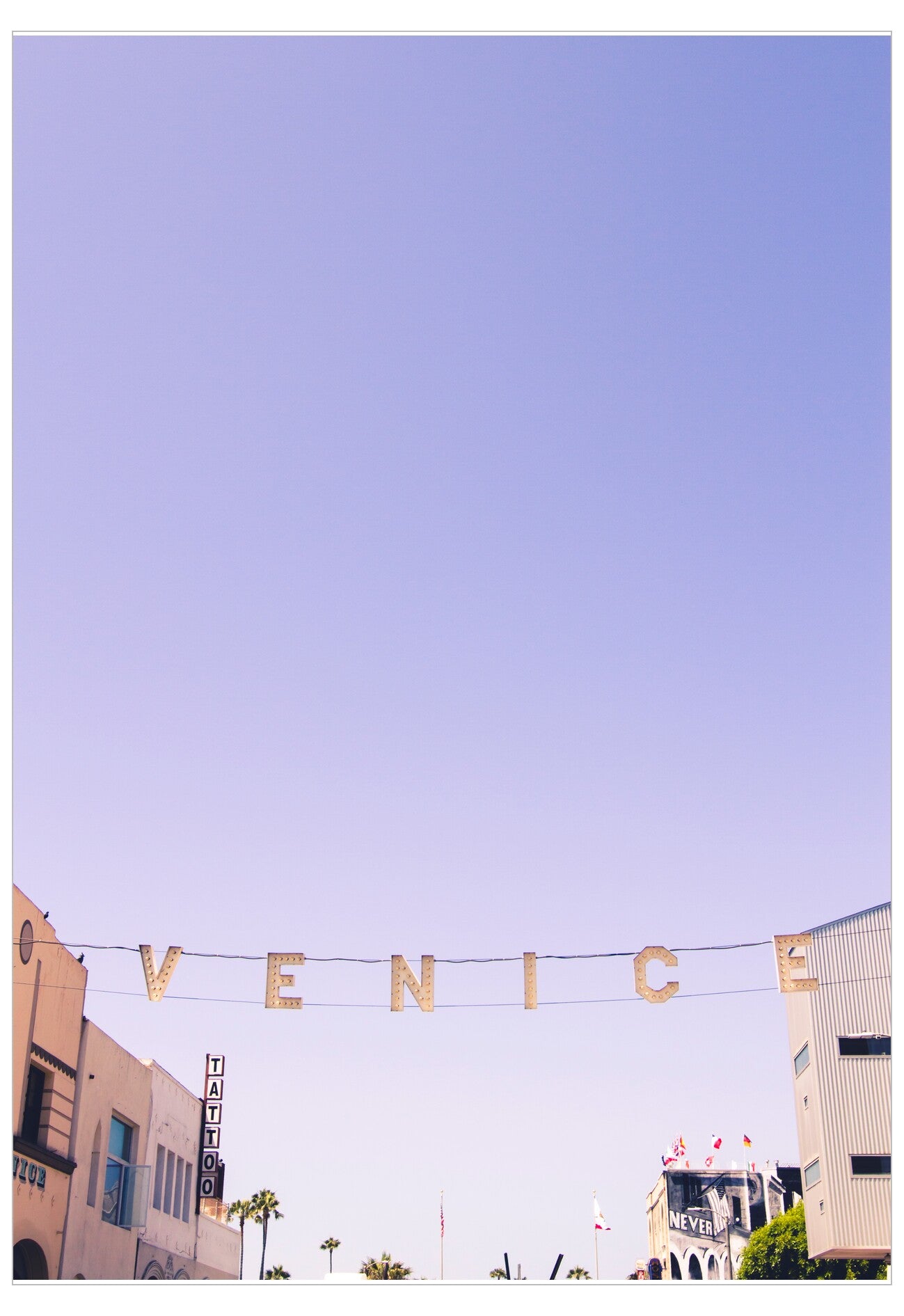 Street sign spelling 'Venice' against a clear blue sky.