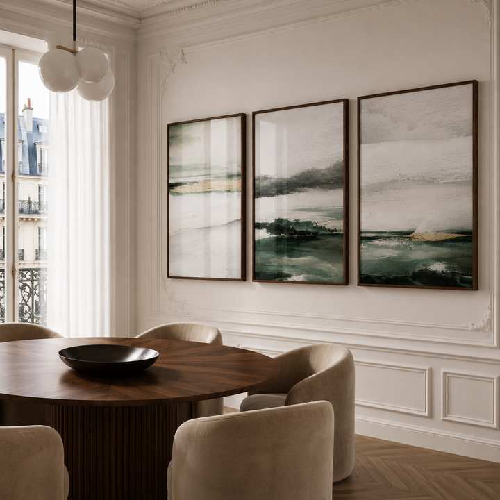 Dining room with a round wooden table and chairs, featuring three abstract paintings on the wall.