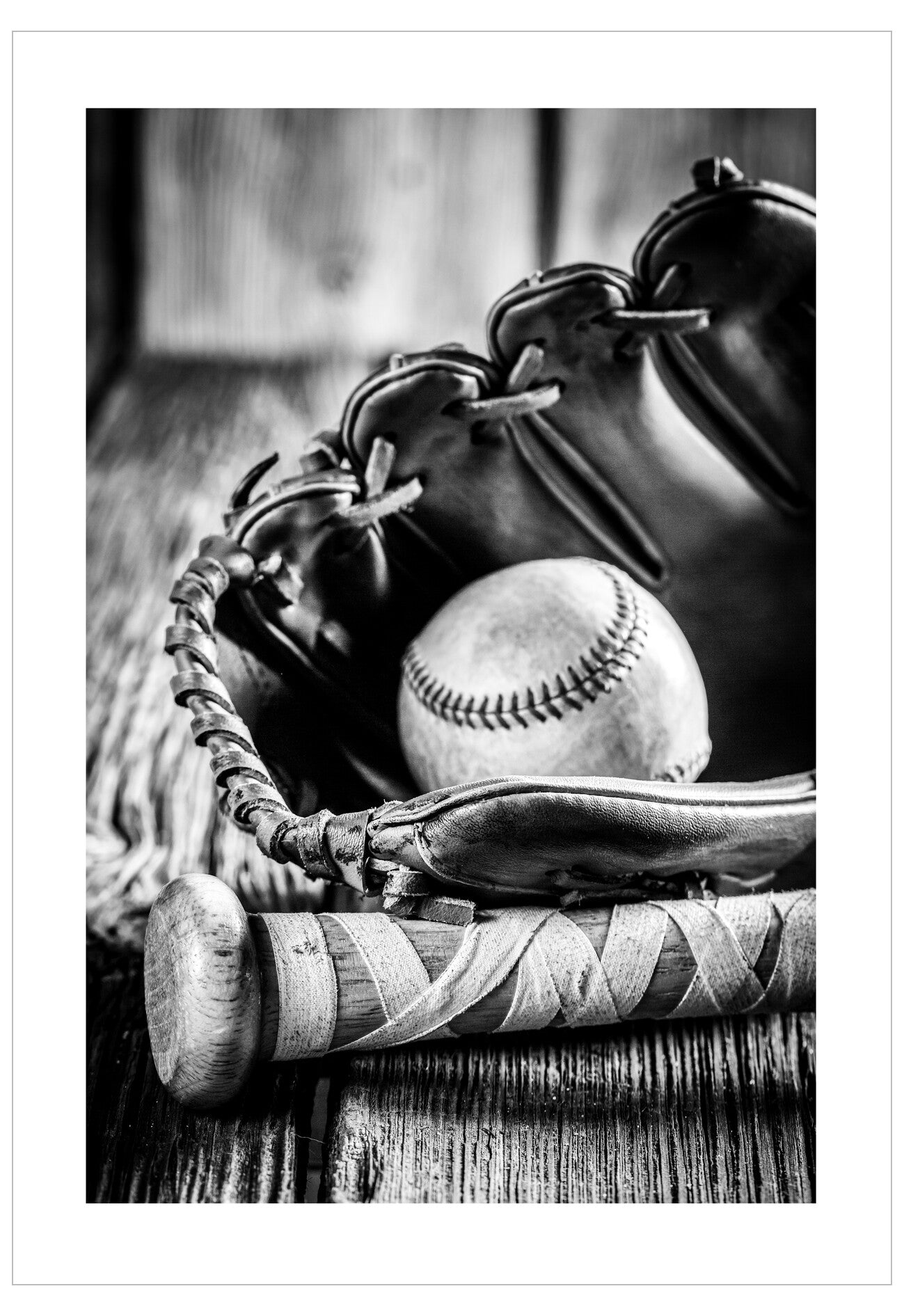 Baseball glove with a baseball and a bat on a wooden surface