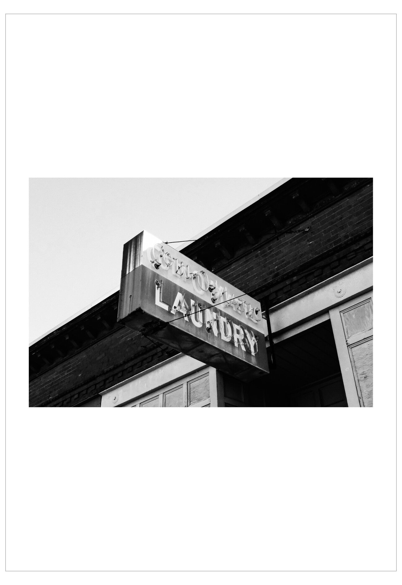 Black and white photo of a laundry sign on a building exterior